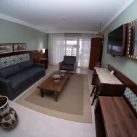 Suíte Master - Ante Sala - Ante sala climatizada, com TV de LCD com canal a cabo, poltronas, mesa de apoio e varanda.
